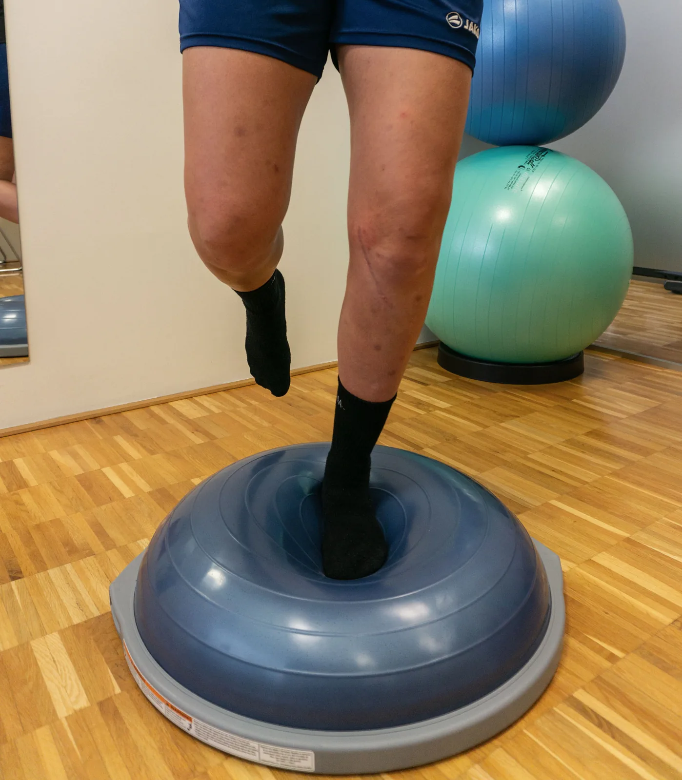 Koordinationsübung im Einbeinstand auf dem Balance-Pad